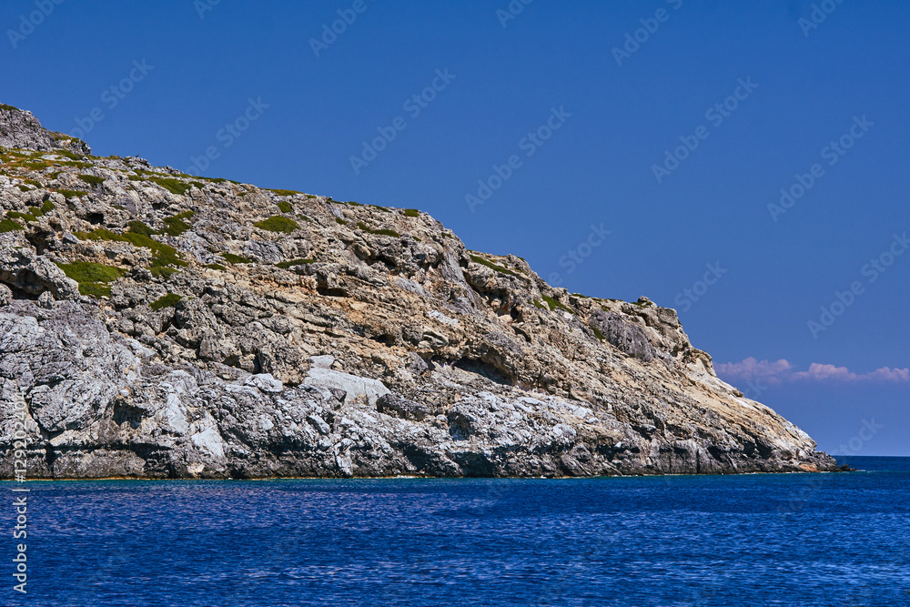 rocky cliff at the edge of the Mediterranean Sea, on the island of Rhodes.