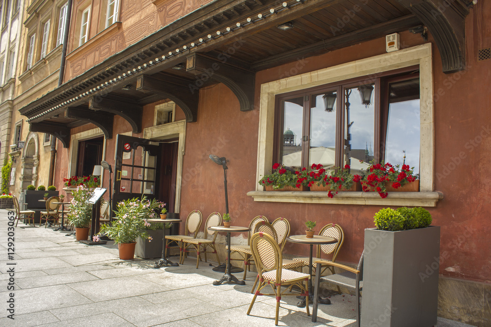 Fototapeta premium Street Cafe. Stoły, krzesła, kwiaty w doniczkach.