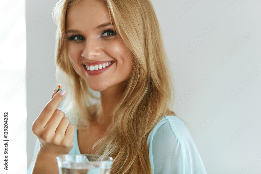 Beautiful Smiling Woman Taking Vitamin Pill. Dietary Supplement - obrazy, fototapety, plakaty 