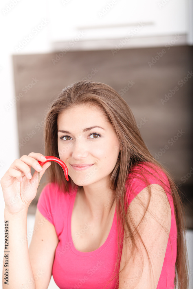 Portrait of a beautiful young girl with chili pepper. Portrait of a beautiful young girl with chili pepper.