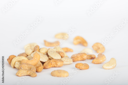 Raw and roasted cashew nuts on white background