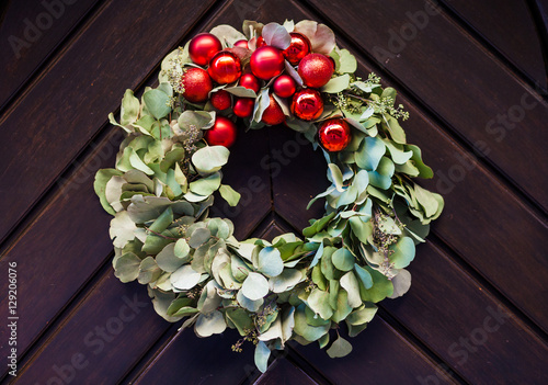 Fotografie Before Christmas an advent wreath hanging on a wooden door