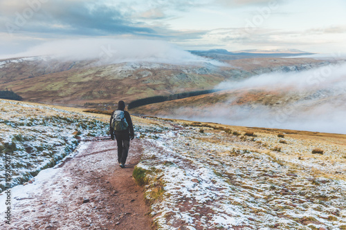 Man walking on snowy hills in winter photo