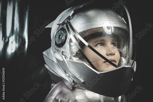Boy playing to be an astronaut with space helmet and metal suit
