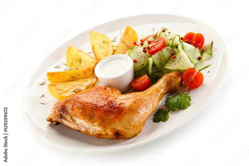 Grilled chicken legs with chips and vegetables isolated on white background Grilled chicken legs with chips and vegetables isolated on white background
