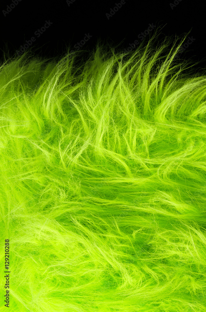 Yellow green fabric on black background vertical. Very soft polyester textile made of synthetic fibers with long hairs. Macro close up material photography, front view. Yellow green fabric on black background vertical. Very soft polyester textile made of synthetic fibers with long hairs. Macro close up material photography, front view.