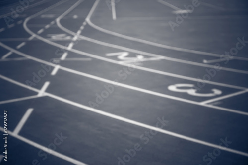 Black and white, blurred image of running track with numbers from 1 to 3. Curves of a Running Track. 