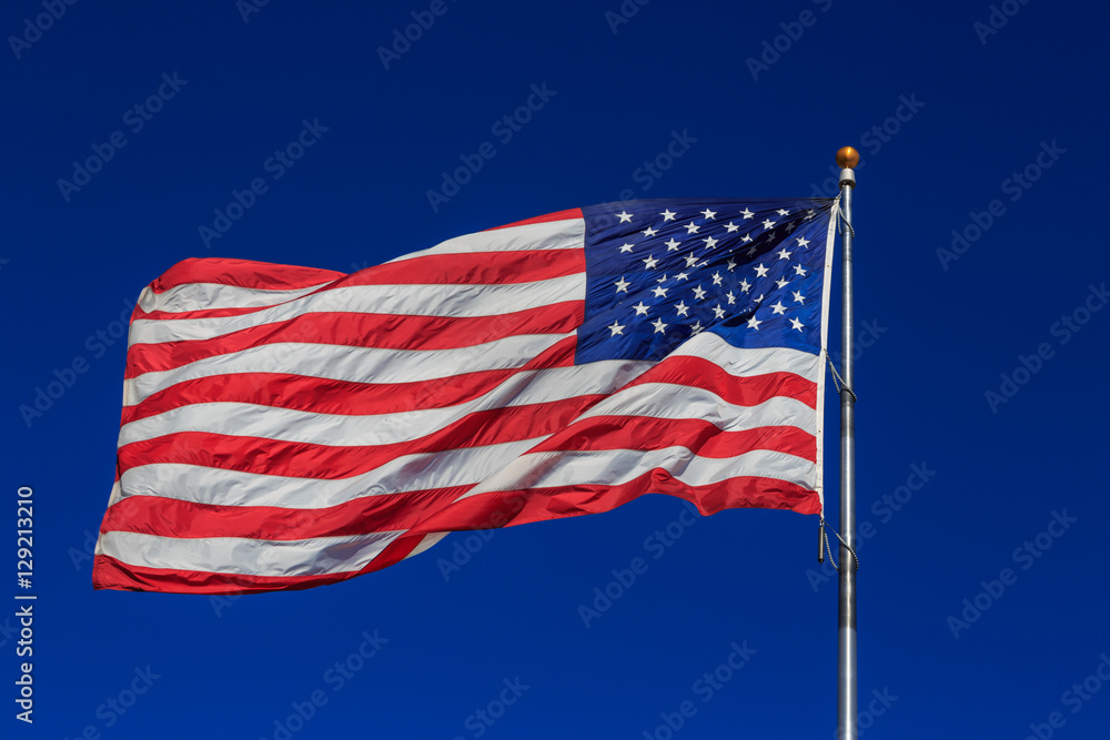 Obraz premium American flag waving in clear blue sky