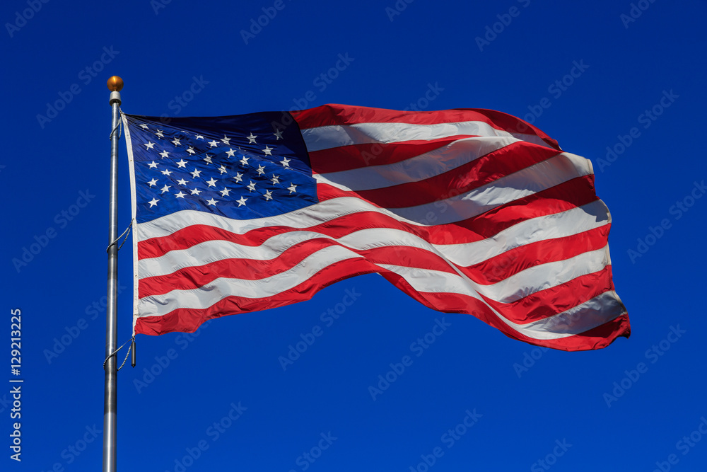 American flag waving in clear blue sky American flag waving in clear blue sky