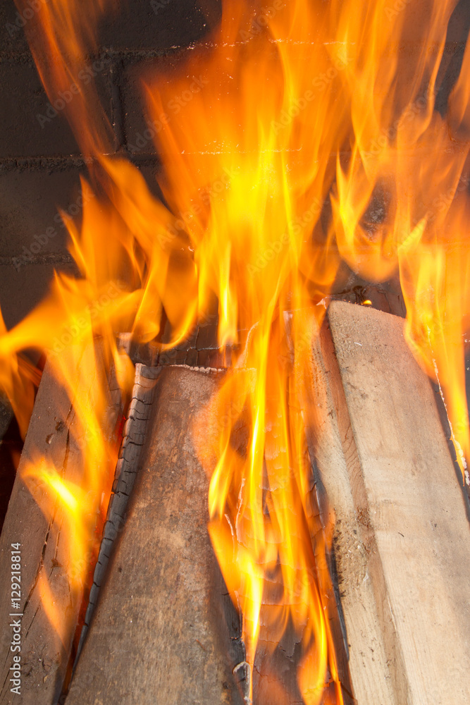 Obraz premium Burning firewood in the fireplace close up