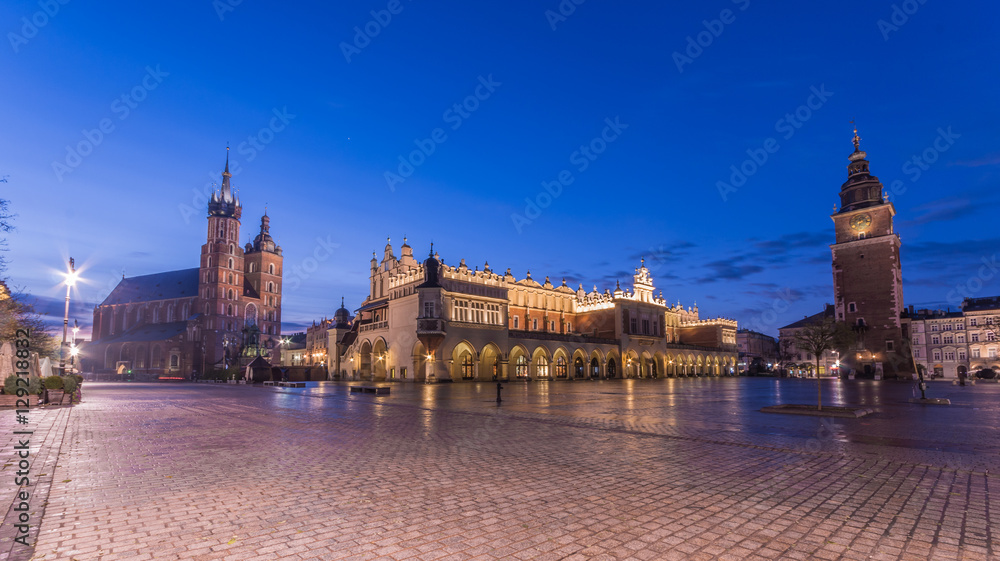 Fototapeta premium St Mary's church, Cloth Hall and Town Hall tower on the Main Market Square in Krakow, illuminated in the morning