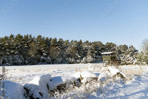 Ett jakttorn på ett snöigt fält photo