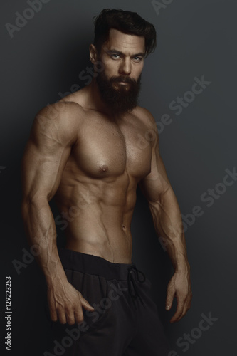 bearded bodybuilder against the dark wall