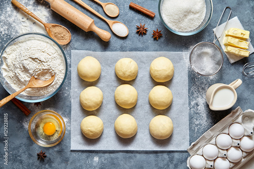 Buns dough traditional homemade preparing recipe, ingridients food flat lay on kitchen table background. Working with butter, milk, yeast, flour, eggs, sugar pastry or bakery cooking.