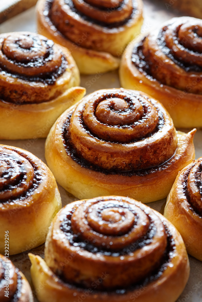 Sweet cinnamon rolls buns with spices and cocoa. Close-up. Kanelbulle - swedish sweet homemade dessert. Christmas baking pastry.