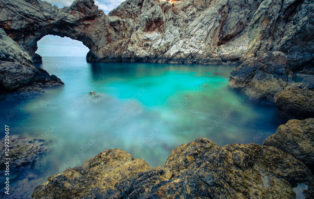 A small sea lagoon with a stone arch, Crete, Greece