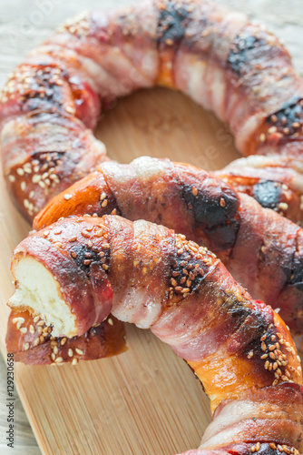 Bagels with sesame wrapped in bacon rashers photo