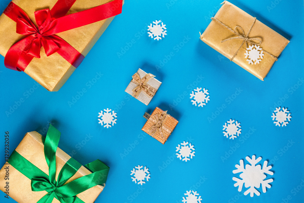 Top view of Christmas items on a blue table. Composition includes decorations, snowflakes, berries and twigs with gifts. Top view of Christmas items on a blue table. Composition includes decorations, snowflakes, berries and twigs with gifts.