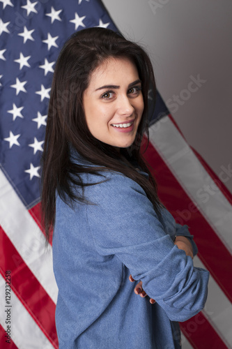 Happy young woman on a background of the American flag © Andrey_Arkusha