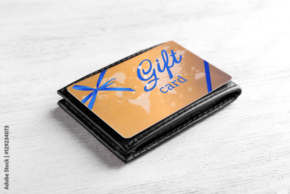 Gift card with wallet on white wooden background. Holiday celebration concept. Gift card with wallet on white wooden background. Holiday celebration concept.