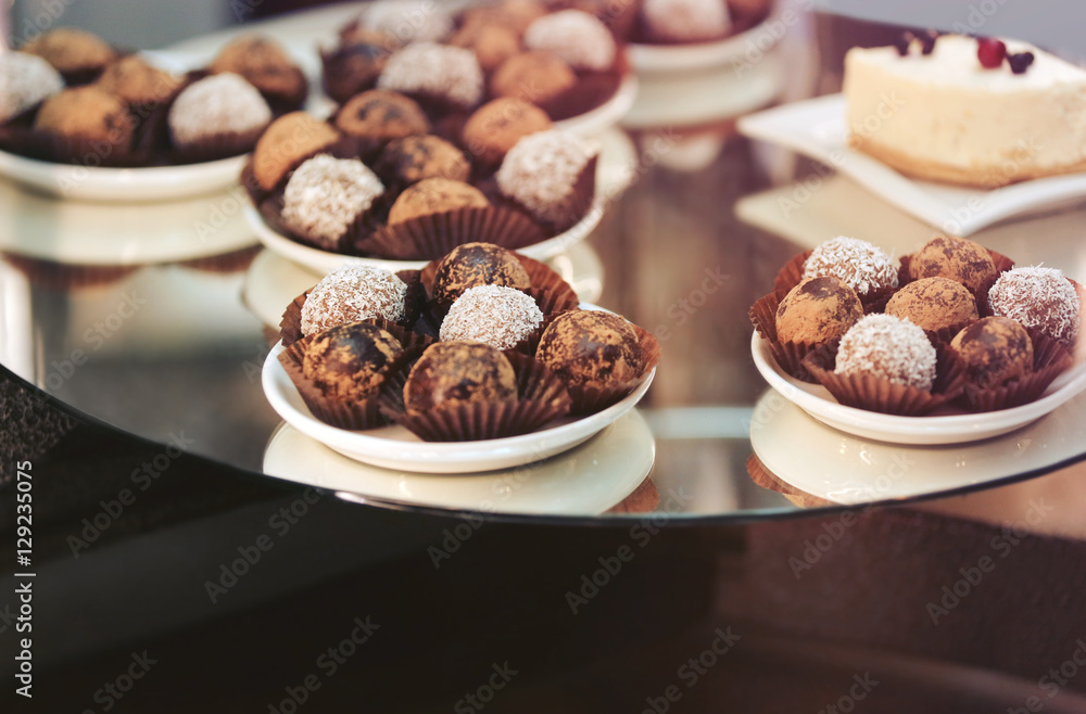 Glass stand with tasty sweets in cafe, close up view Glass stand with tasty sweets in cafe, close up view