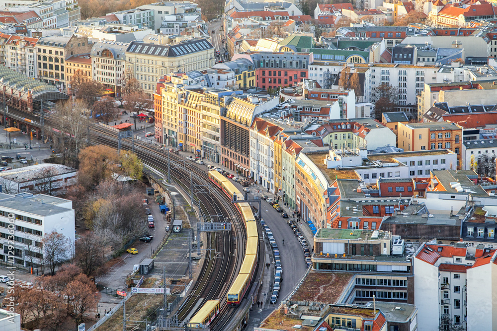 Obraz premium Beautiful panoramic aerial view over Berlin down onto S-Bahn tracks (rapid train) and colorful buildings at sunset.