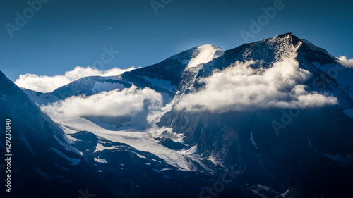 Montagne innevate tra le nuvole presso il Grossglockner in Austria photo