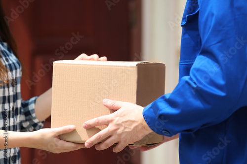 Male deliverer giving box to client © Africa Studio