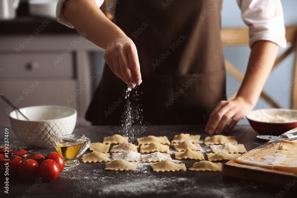 Woman making ravioli on table