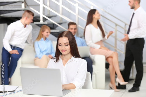 Beautiful young woman working with laptop in office