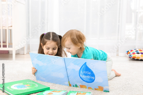 Cute girl reading book with...