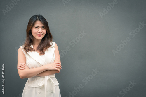 Pretty beautiful smiling confident Asian woman on gray wall background