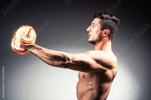 Muscular ripped bodybuilder with burning dumbbells © Elnur