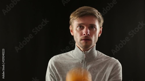 close up portrait of young caucasian man juggling oranges