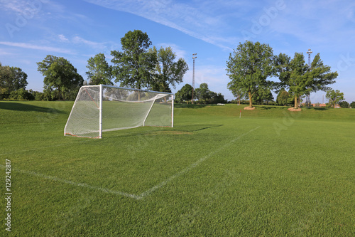 A view of a net on a vacant soccer pitch in morning light.. photo