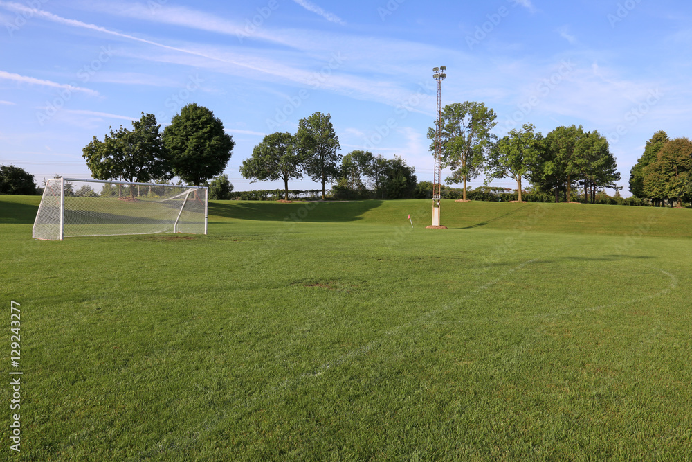 A view of a net on a vacant soccer pitch in morning light.. A view of a net on a vacant soccer pitch in morning light..