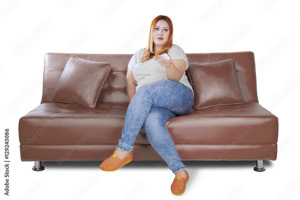 Obraz premium Fat woman watches tv on sofa