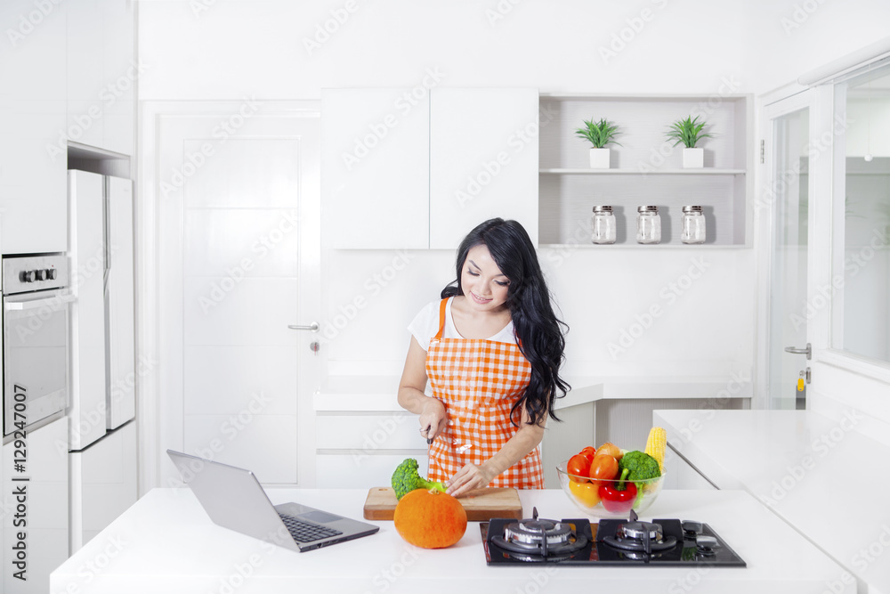 Woman chopping broccoli in the kitchen