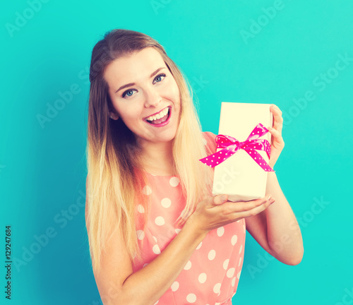 Happy young woman holding a gift box