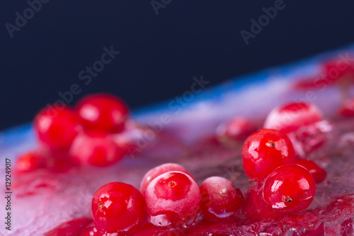 Красная ягода и лёд. \ Красная ягода,замороженная ягода во льду, лёд с синим отливом, чёрный фон.