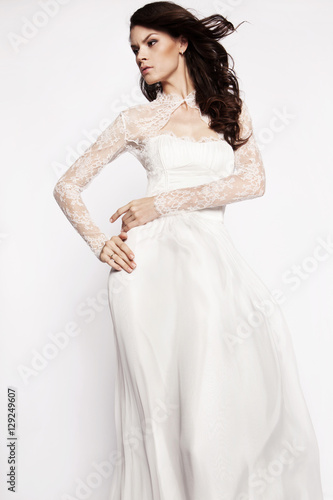 Brunette model in white dress posing
