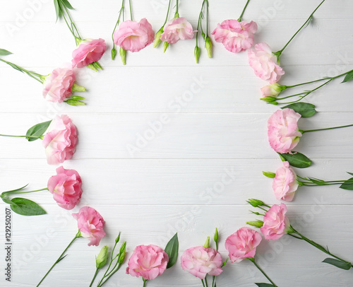 Fresh pink flowers frame on wooden background