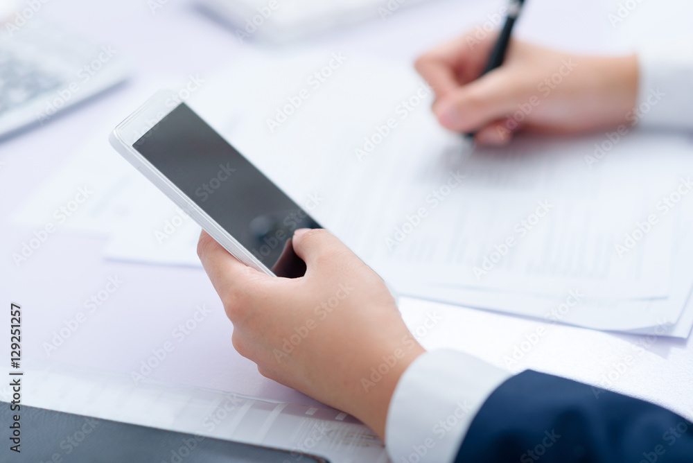 Businesswoman using smart phone work at desk. Businesswoman using smart phone work at desk.