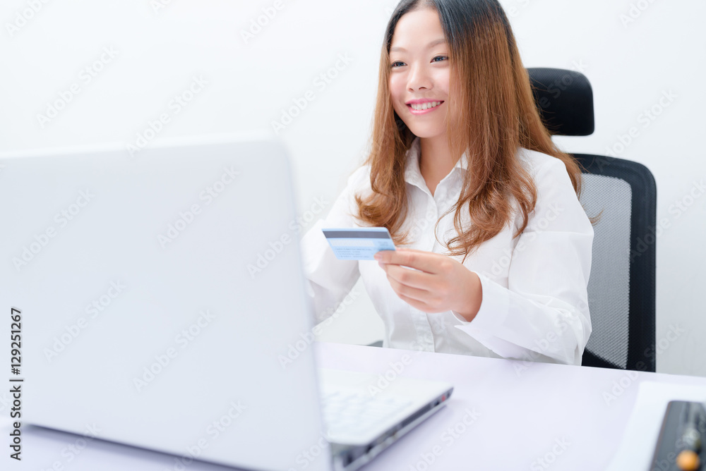Young woman using credit card paying on laptop. Young woman using credit card paying on laptop.