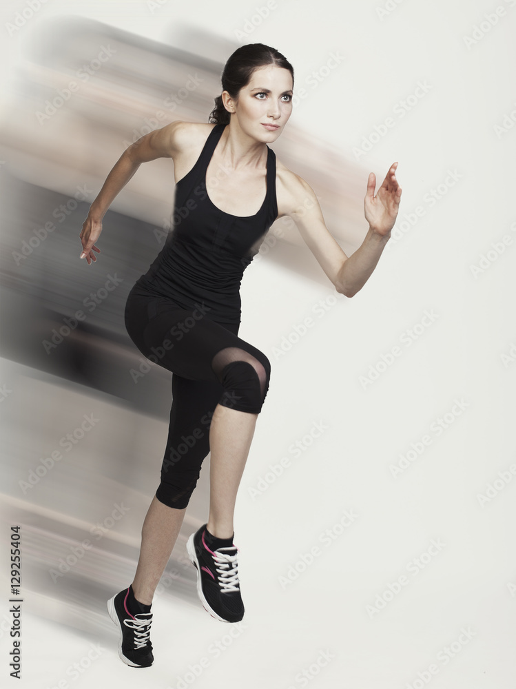 Young running caucasian woman studio isolated on bg with blur mo Young running caucasian woman studio isolated on bg with blur mo