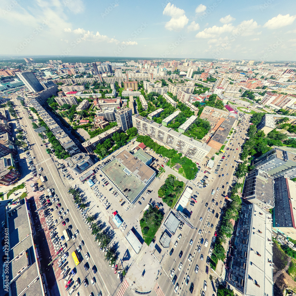 Fototapeta premium Aerial city view with crossroads and roads, houses, buildings, parks and parking lots, bridges. Urban landscape. Copter shot. Panoramic image.