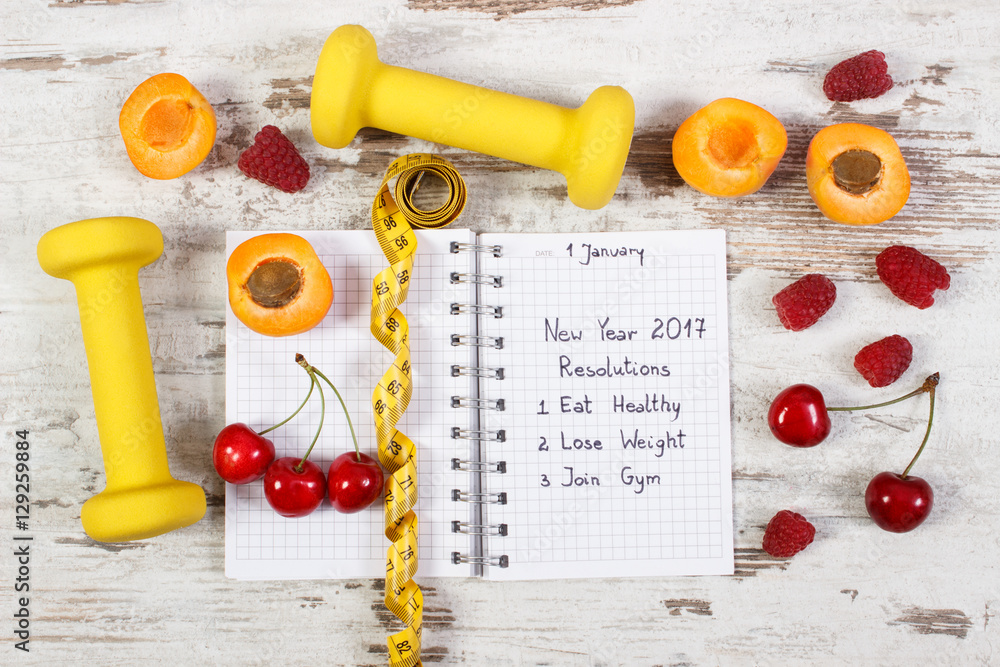 New year resolutions written in notebook on old board New year resolutions written in notebook on old board