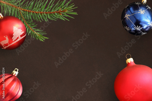 Dark background with Christmas fir branch, red wavy dull and blue ball photo