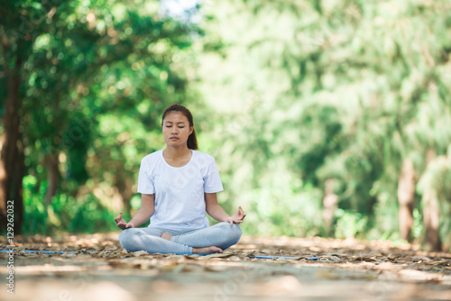 Young asian woman doing yoga in the morning at the park. Healthy