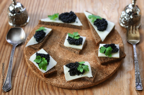 snack black caviar on a wooden background